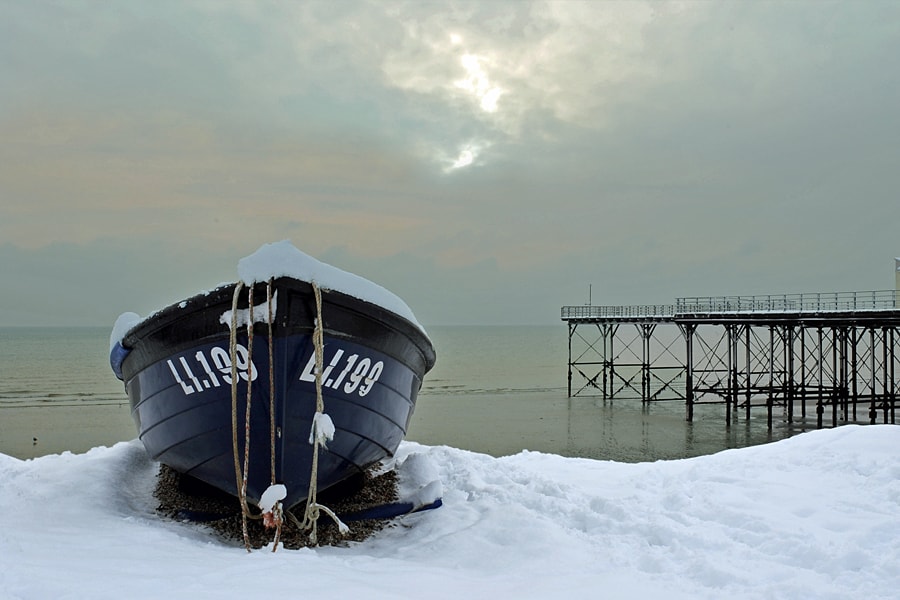 Fishing boat in the snow on the beach at Bognor Regis, West Sussex