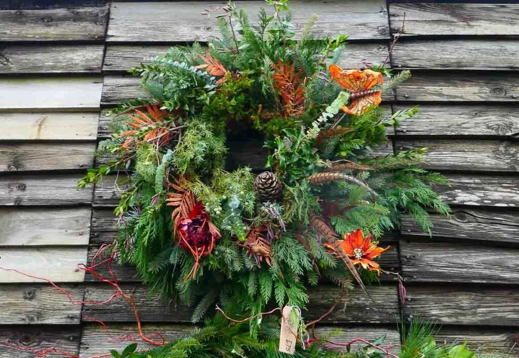 Rustic Christmas wreath against wooden boards at Sussex Christmas market.