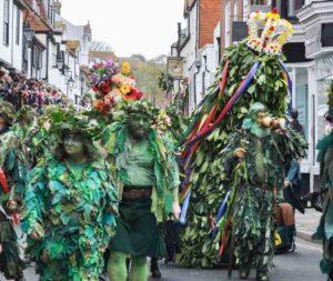 Jack in the Green Hastings. Parade of people dressed in green foliage costumes with Jack a towering costume with a crown on top to symbolise the start of summer