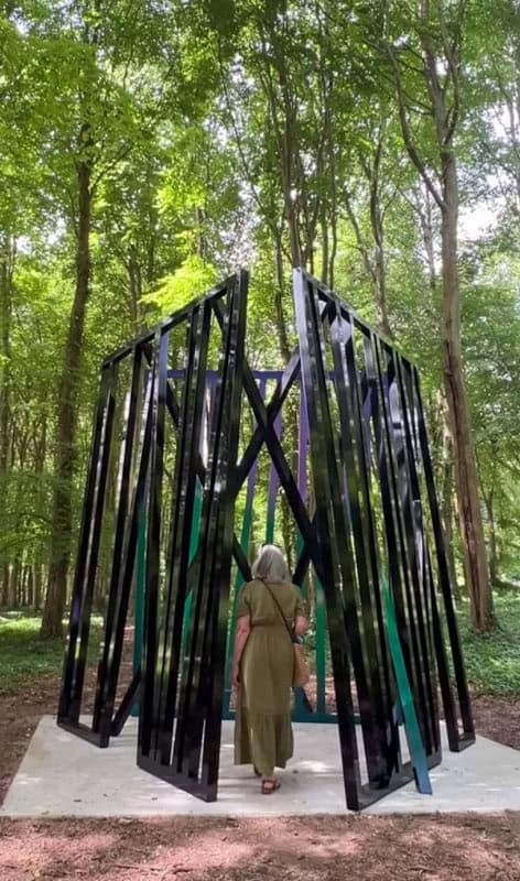A womqn walks into Eva Rothschild's alluminium sculpture Cosmos