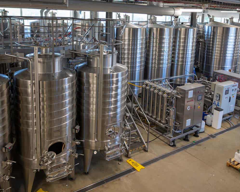 Tall metal tanks holding wine stand in a state of the art winery at Rathfinny, East Sussex