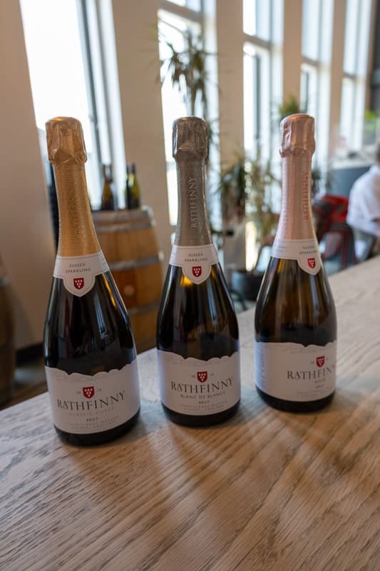Four glasses of wine on a table at a wine tasting. One still, two white Sussex Sparkling and one sparkling rose